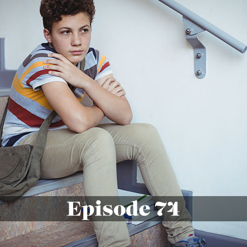 Sad boy sitting on steps at school in post about mental health in the school setting