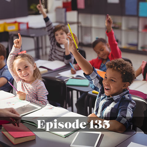 Diverse elementary students smiling and raising their hands